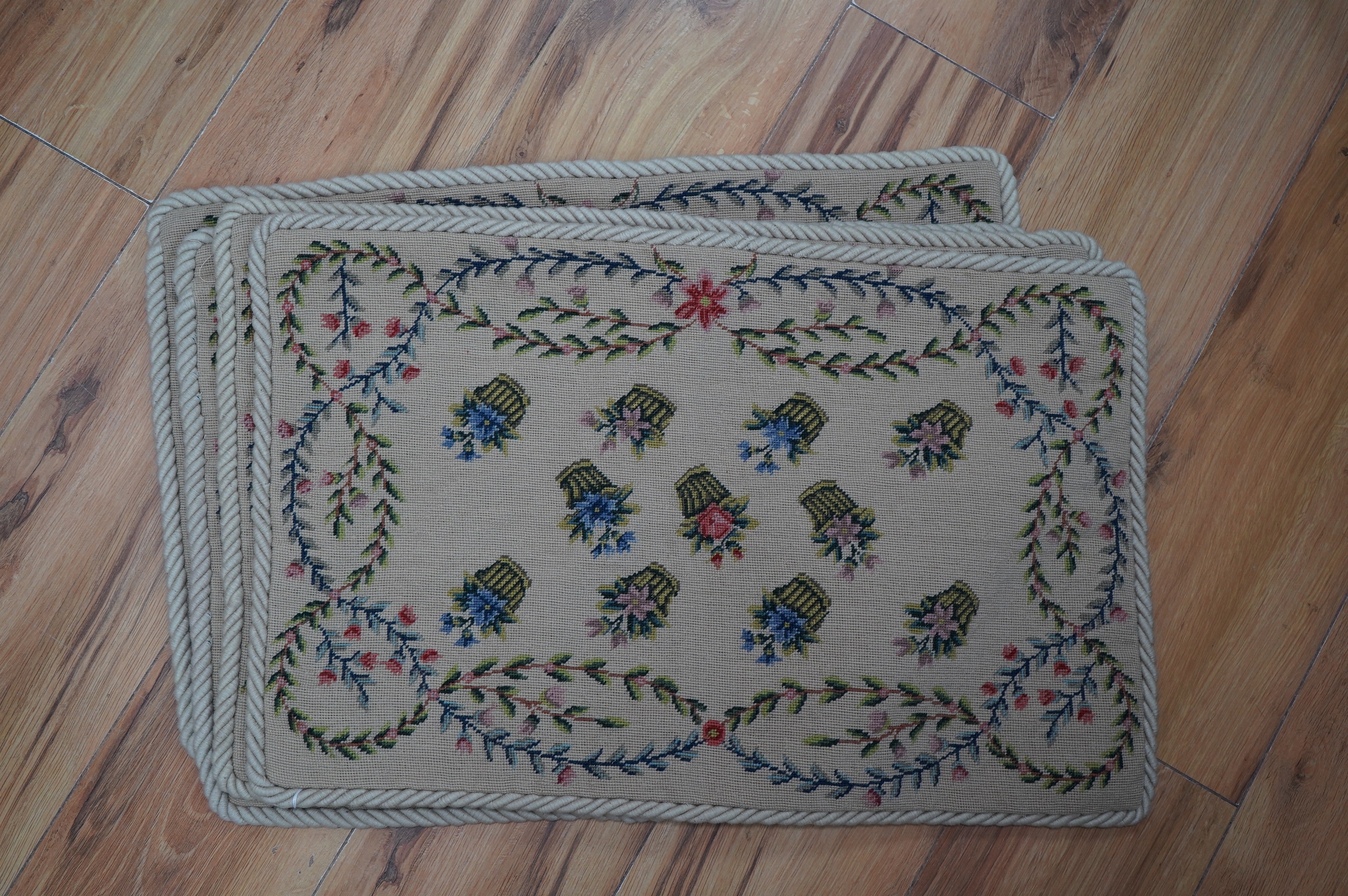 Four floral bouquet and butterfly wool work cushion covers and four similar basket of flowers sprig pattern cushions all edged with mushroom roping, basket sprig pattern 44cm wide, 34cm high. Condition - good